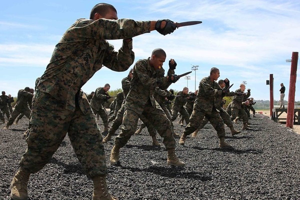 a group of Marines practicing knife thrusting techniques