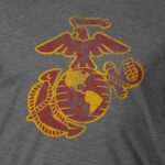 a vintage look Eagle, Globe, and Anchor in red and yellow on a gray Marines shirt
