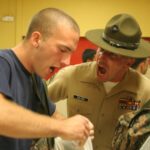 USMC Drill instructor cover correcting Marine corps recruit in San Diego.