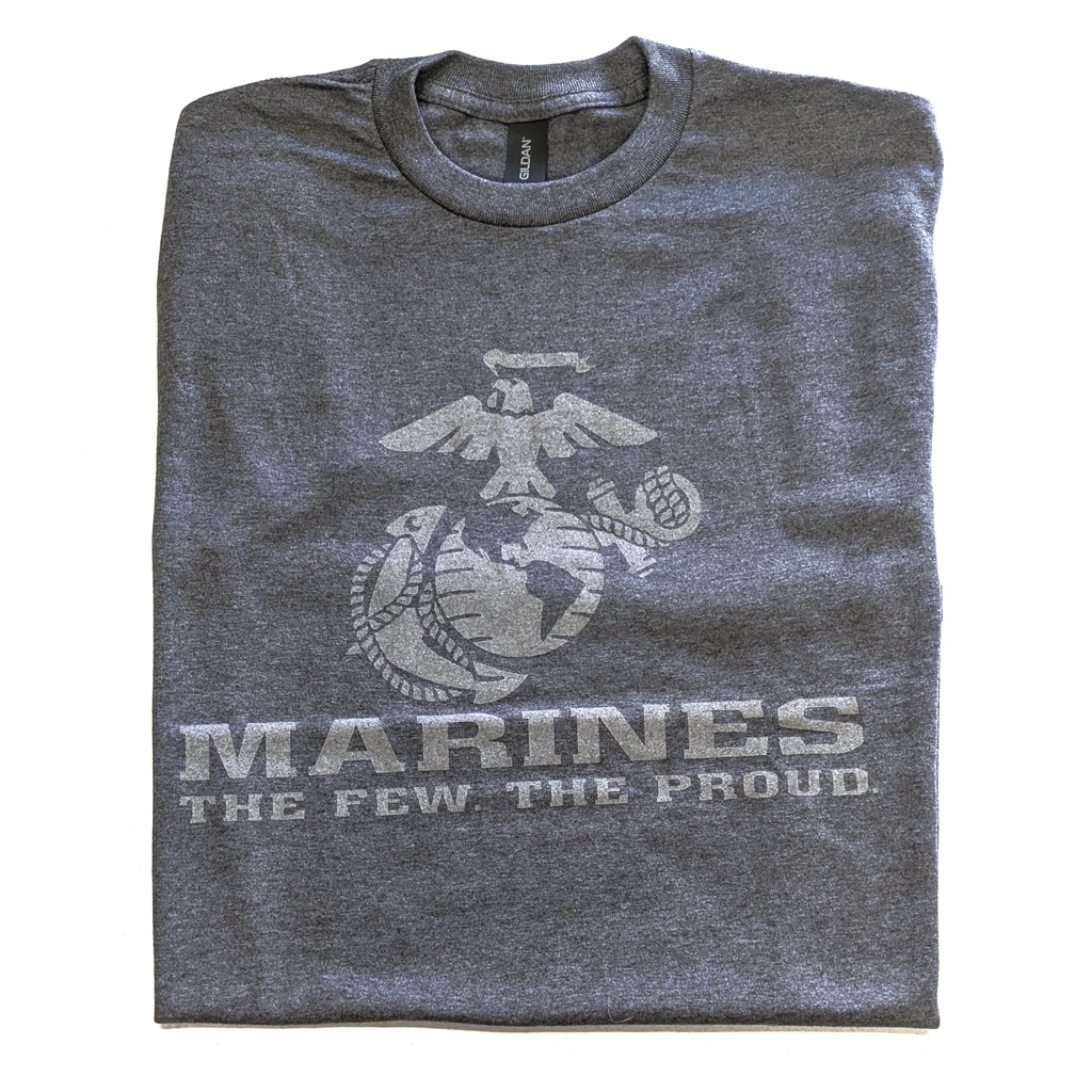 a charcoal gray USMC t-shirt with a large Eagle, Globe, & Anchor, plus the text "MARINES" "THE FEW THE PROUD." The print is light gray and reflective.