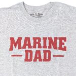 an athletic gray casual Marine Corps shirt for dads with a bold front print in red saying "MARINE DAD"